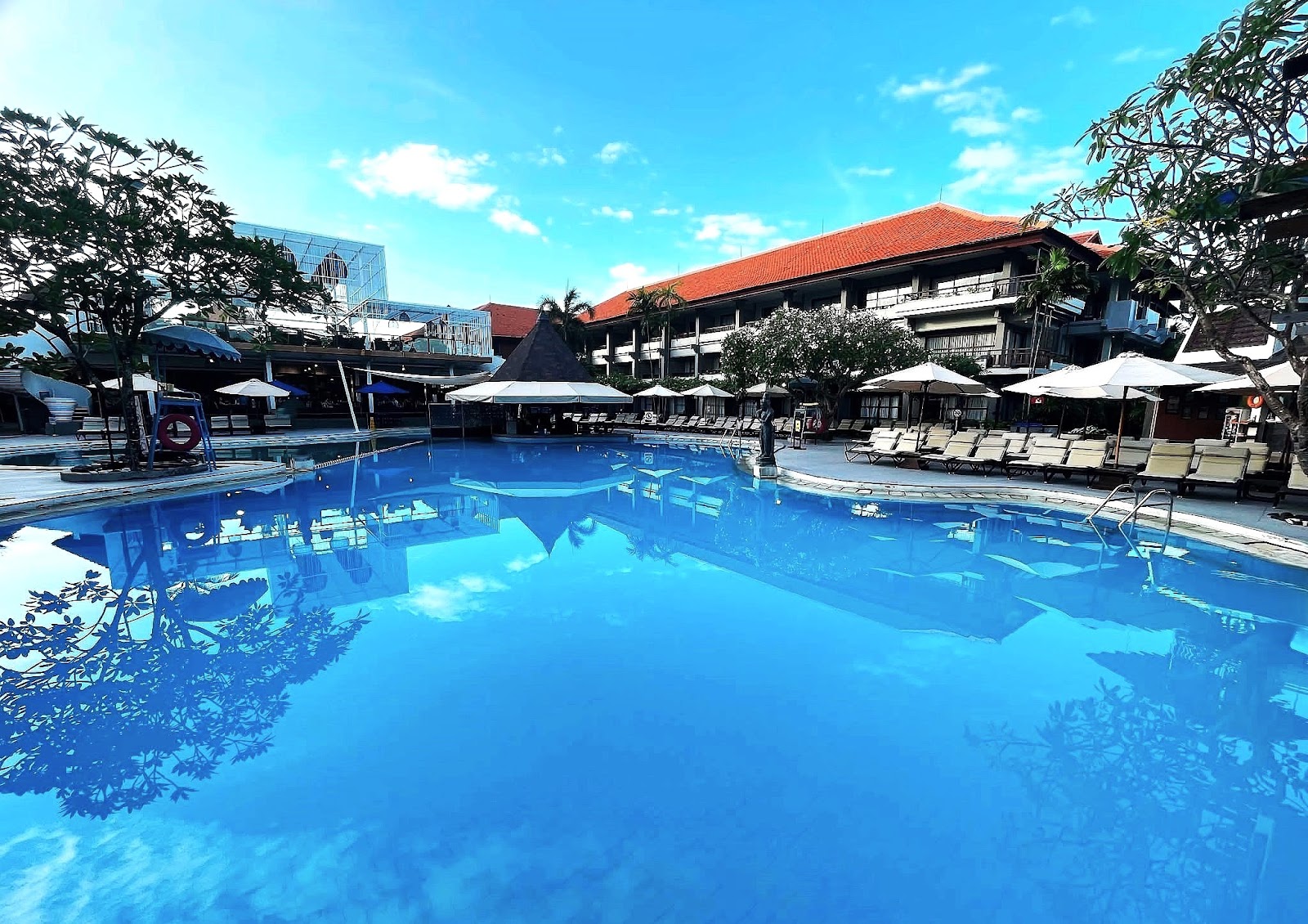 Large swimming pool with sun loungers at Bali Dynasty Resort