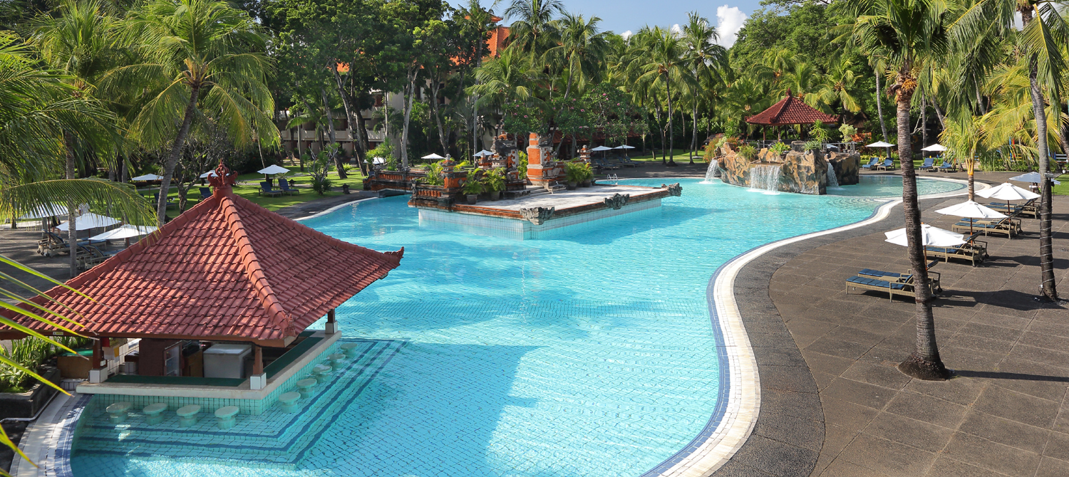 Winding pool with a thatched gazebo at Bintang Bali Resort