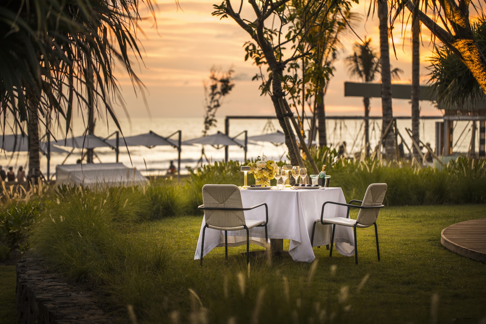 Lawn with dining tables overlooking the ocean at COMO Uma Canggu