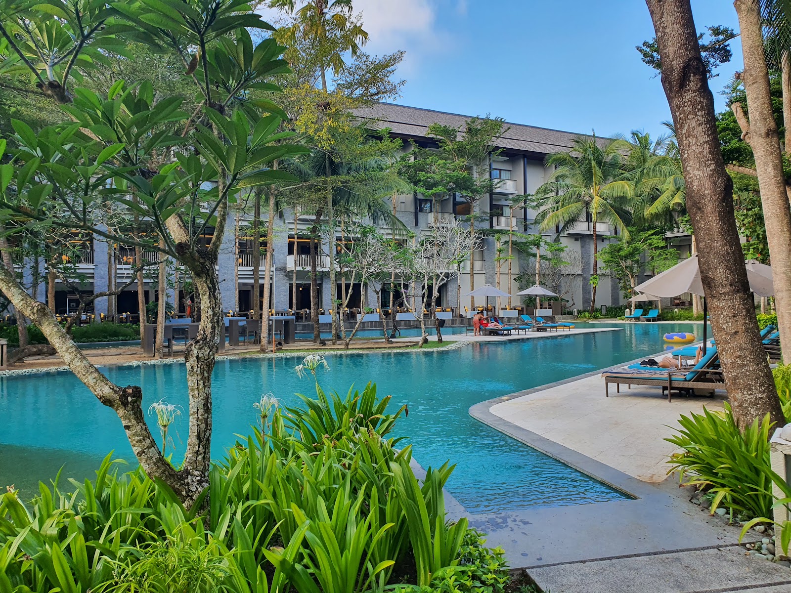 Resort pool lined with palm trees at Courtyard Bali Nusa Dua