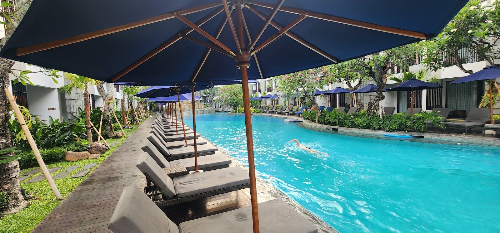 Swimming pool lined with loungers at Courtyard Bali Seminyak Resort