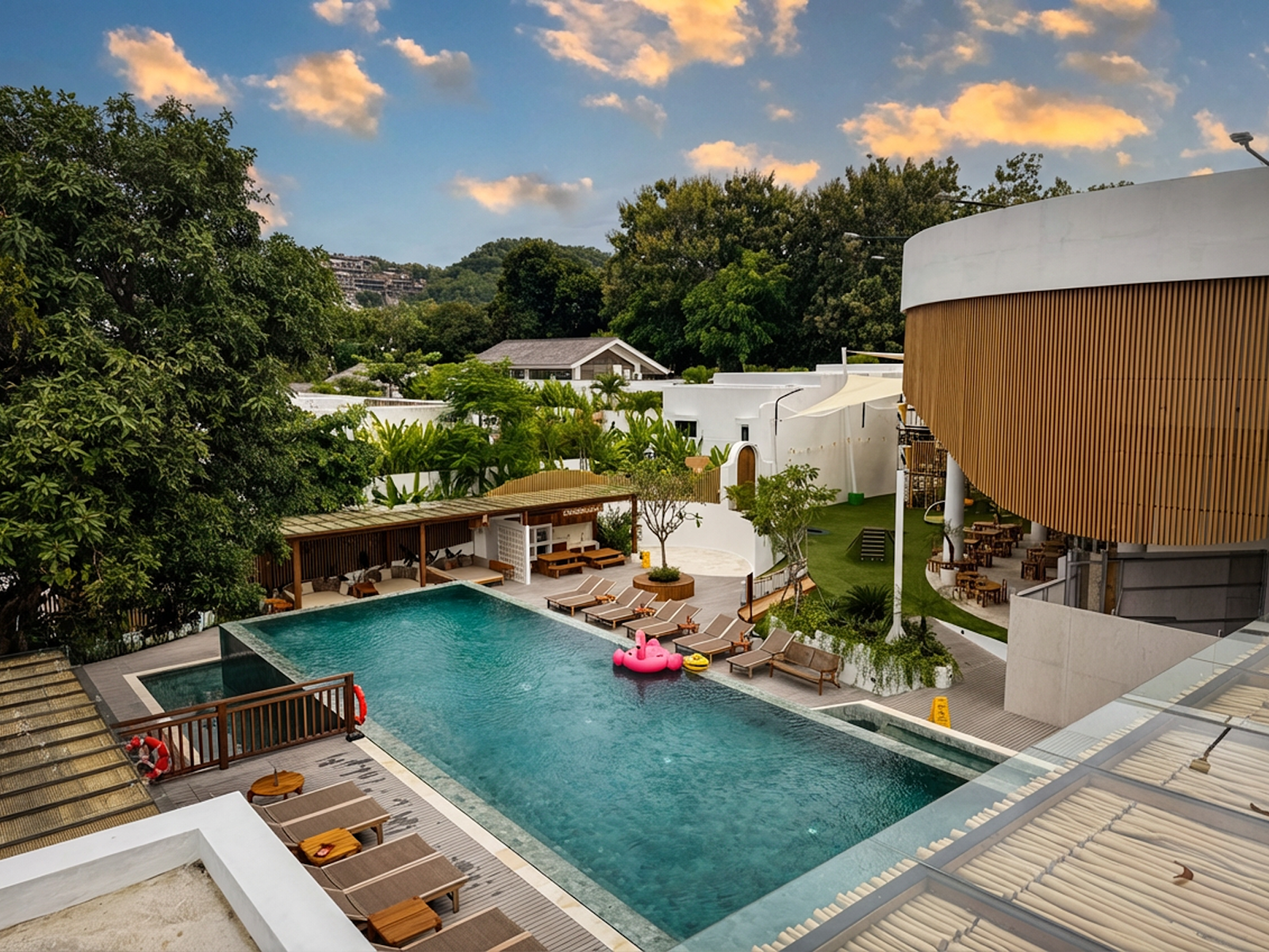 Swimming pool surrounded by gardens at Family Nest Resort and Villas