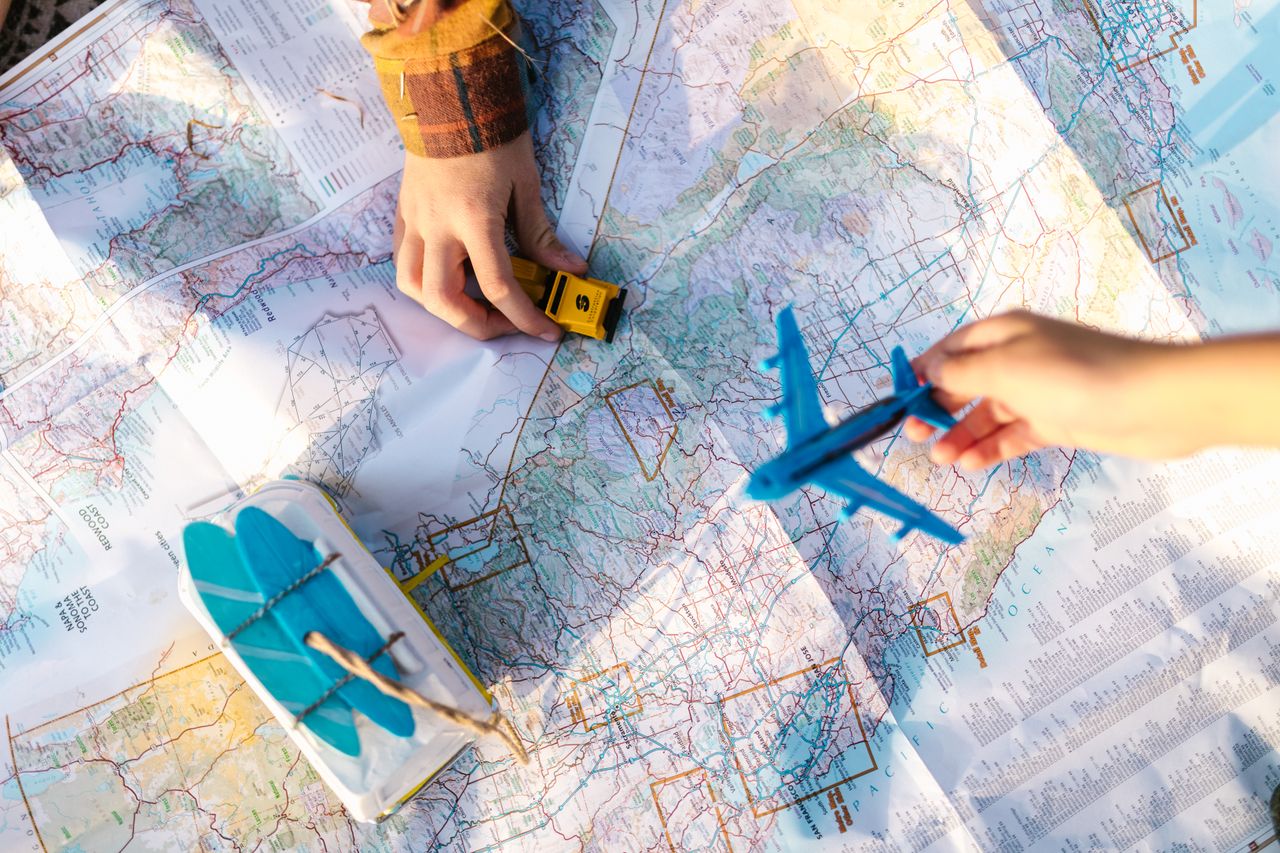 Family planning a trip on a map with a toy airplane