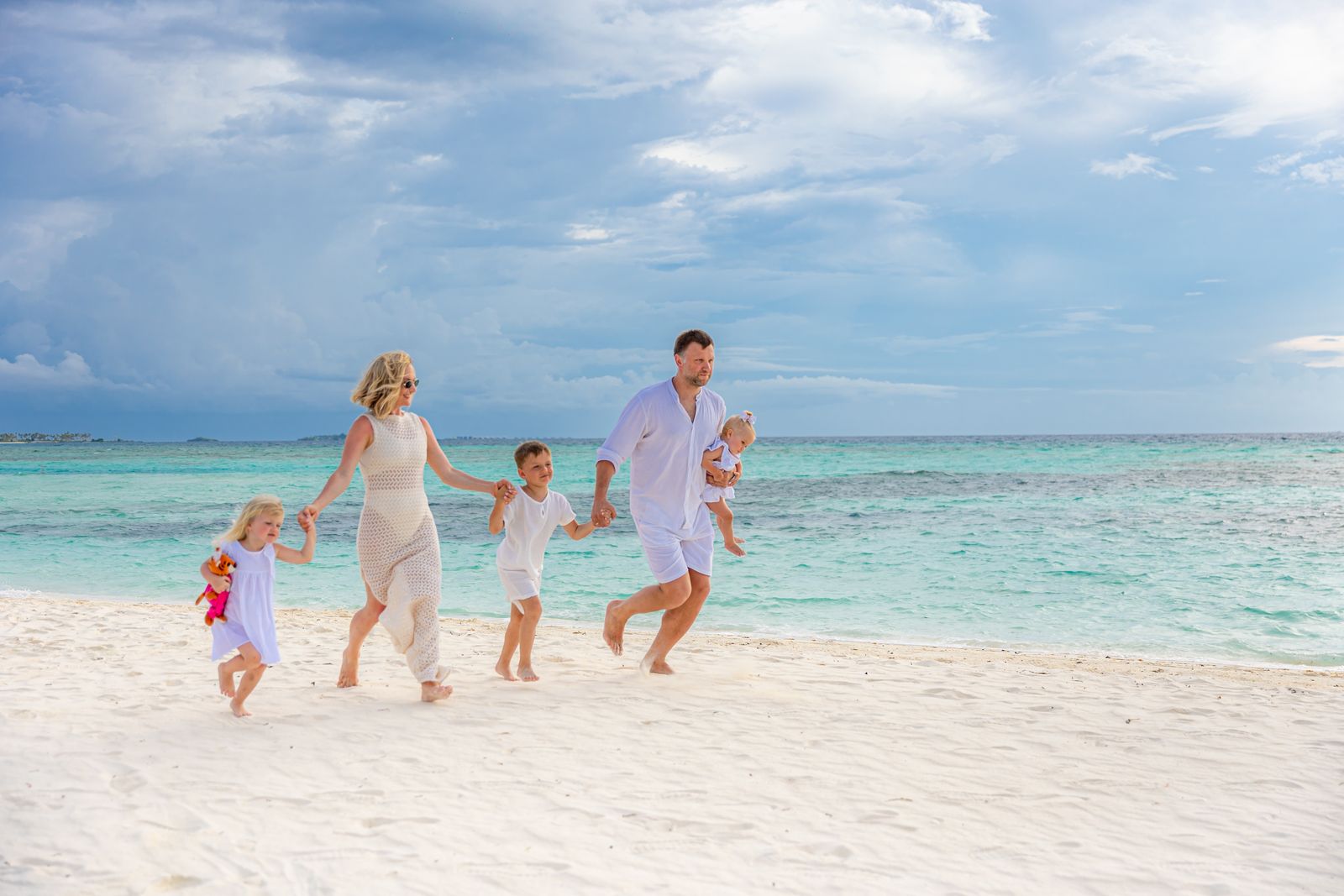 Family walking together along a white sand beach
