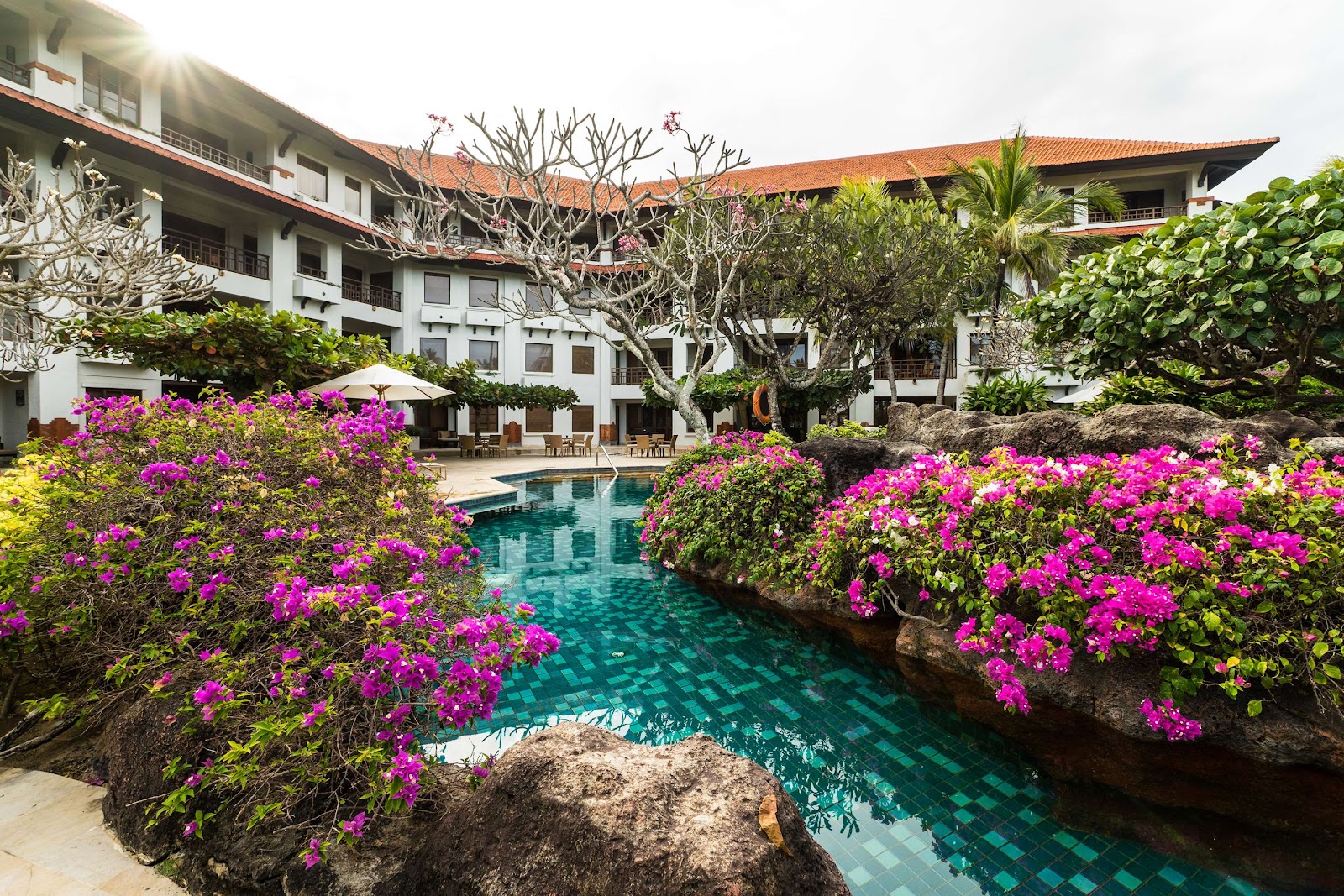 Pool surrounded by tropical flowers at Grand Hyatt Bali