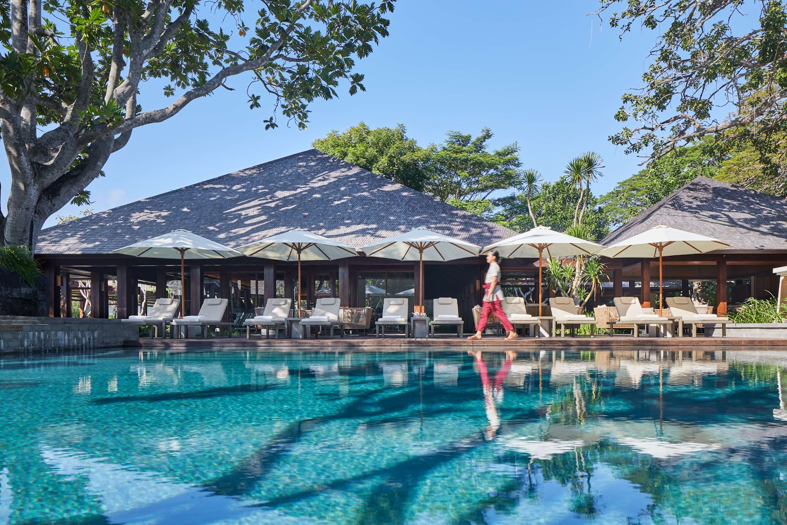 Pool with loungers and palm trees at Hyatt Regency Bali