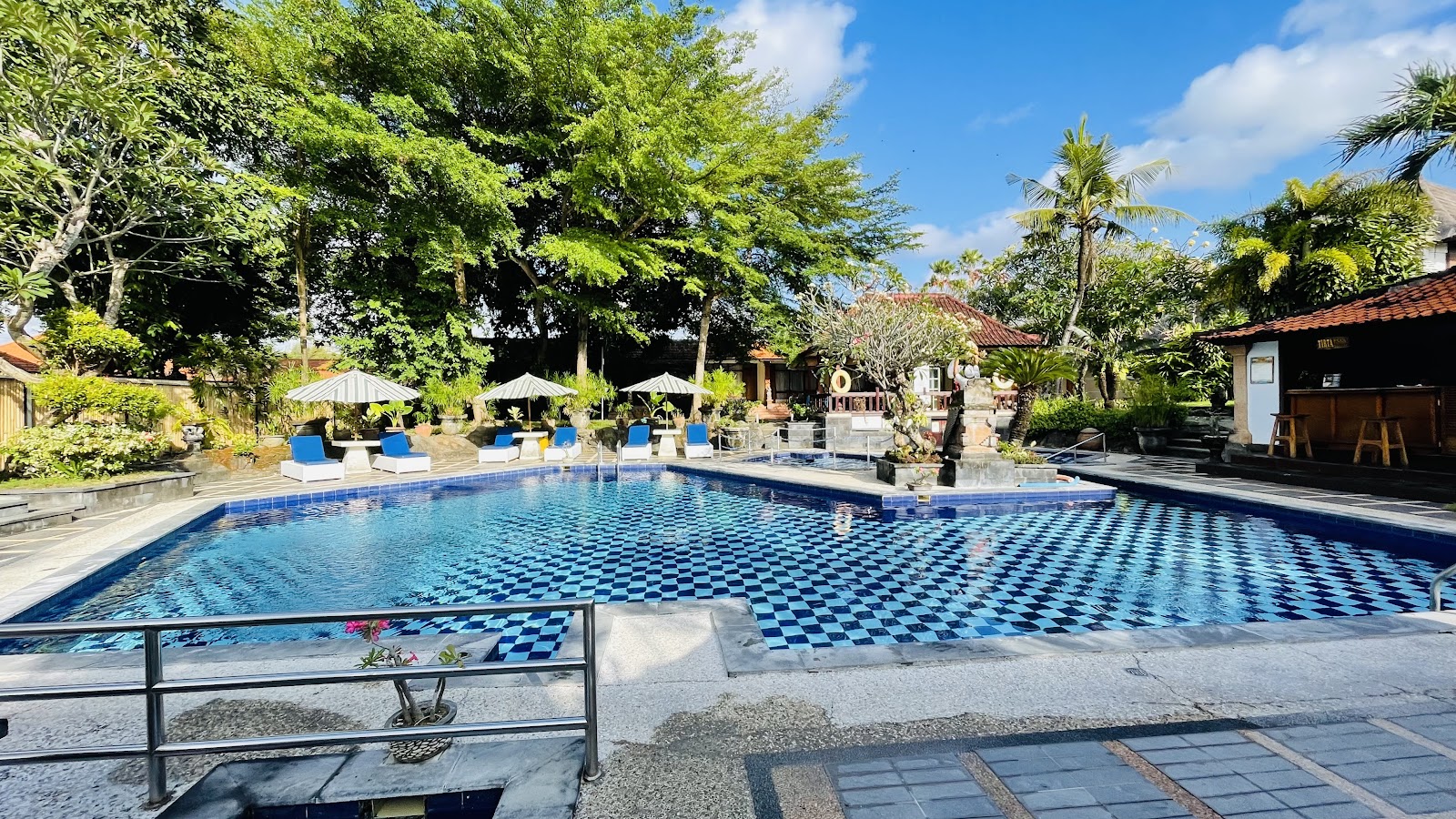 Swimming pool framed by palm trees at Inna Sindhu Beach Hotel