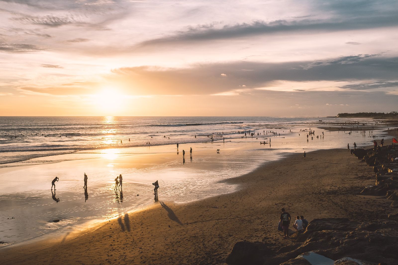People enjoying a golden sunset on the beach