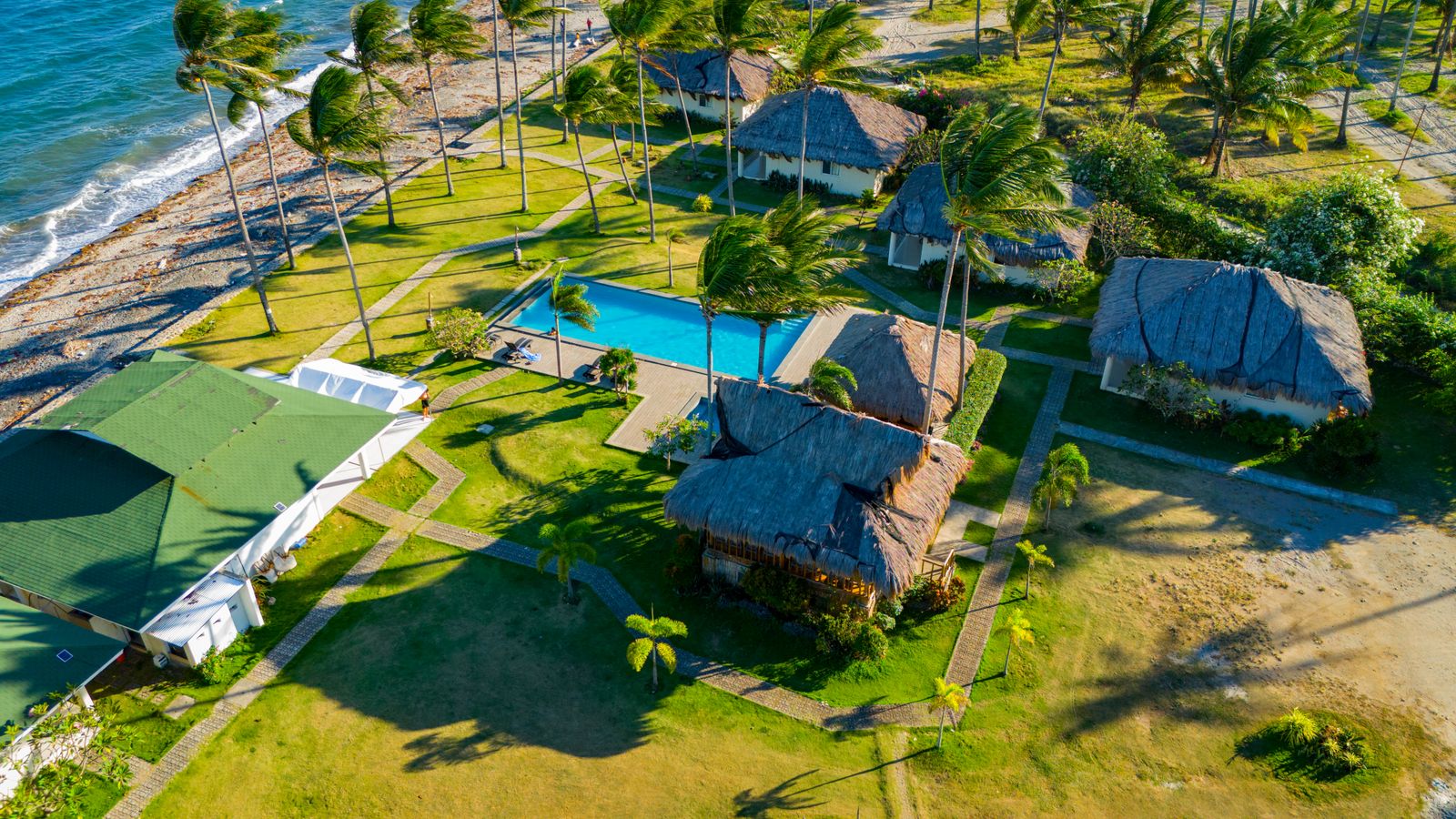 Aerial view of resort villas and a pool surrounded by gardens